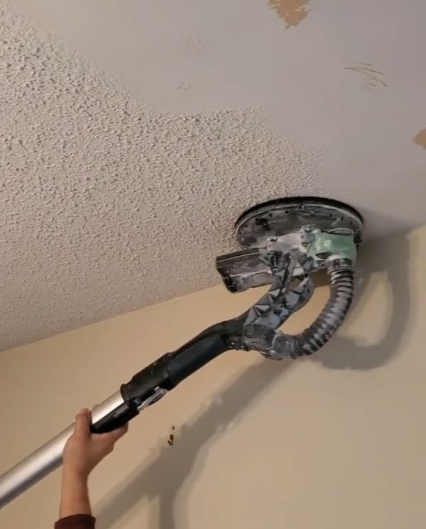 Partially scraped popcorn ceiling revealing the flat surface underneath.